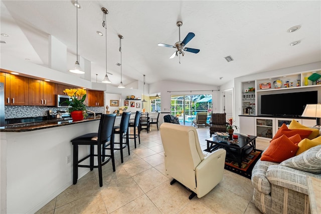 living area featuring visible vents, built in features, a ceiling fan, vaulted ceiling, and light tile patterned flooring