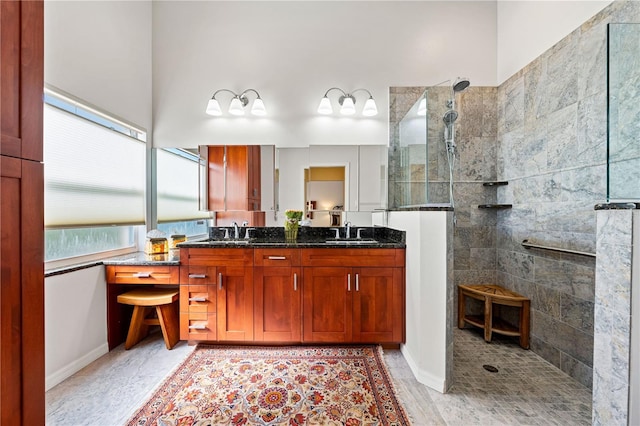 full bath featuring double vanity, a sink, and a walk in shower