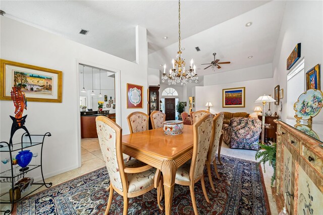 dining area featuring visible vents, light tile patterned flooring, vaulted ceiling, baseboards, and ceiling fan with notable chandelier