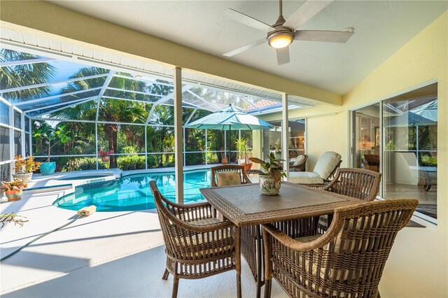 exterior space with ceiling fan, a patio area, a lanai, and a pool with connected hot tub