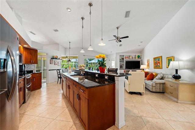 kitchen featuring light tile patterned floors, appliances with stainless steel finishes, open floor plan, and a sink