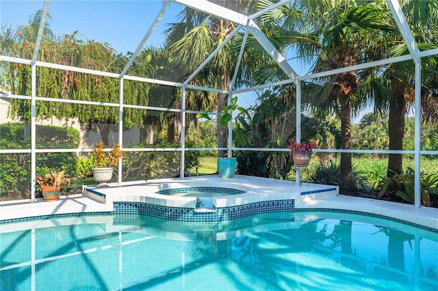 outdoor pool with glass enclosure, a patio, and an in ground hot tub