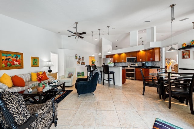 living area featuring high vaulted ceiling, visible vents, ceiling fan, and light tile patterned floors