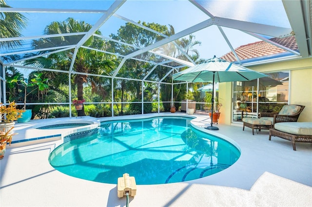 view of swimming pool featuring glass enclosure, a patio area, and a pool with connected hot tub