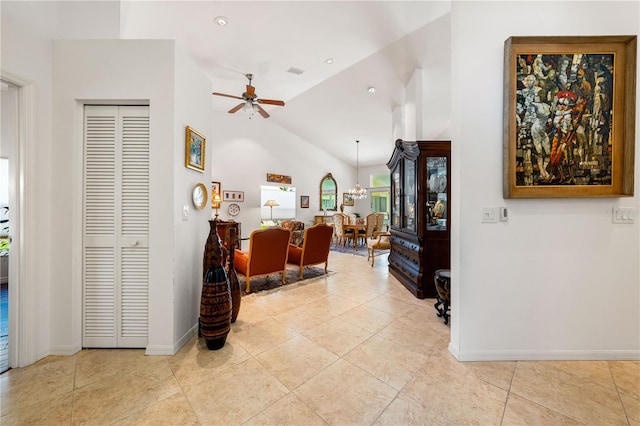 interior space with visible vents, baseboards, lofted ceiling, light tile patterned flooring, and ceiling fan with notable chandelier