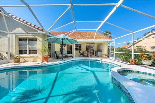 view of swimming pool featuring a lanai, a pool with connected hot tub, and a patio