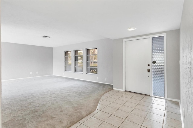 entryway featuring light carpet, baseboards, and light tile patterned flooring