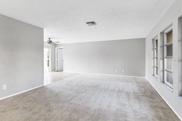 unfurnished room with visible vents, built in features, a textured ceiling, and carpet floors