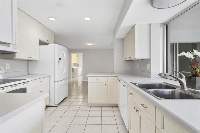 kitchen featuring white appliances, light tile patterned floors, a peninsula, a sink, and light countertops