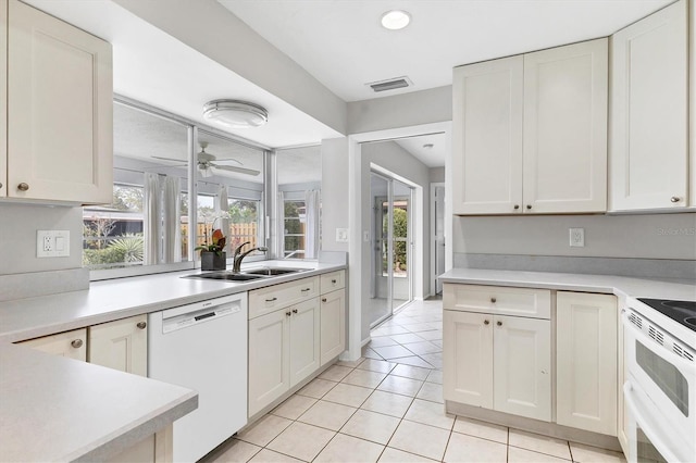 kitchen featuring visible vents, ceiling fan, light countertops, white appliances, and a sink