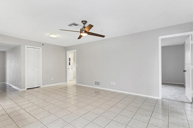 spare room with baseboards, visible vents, and ceiling fan