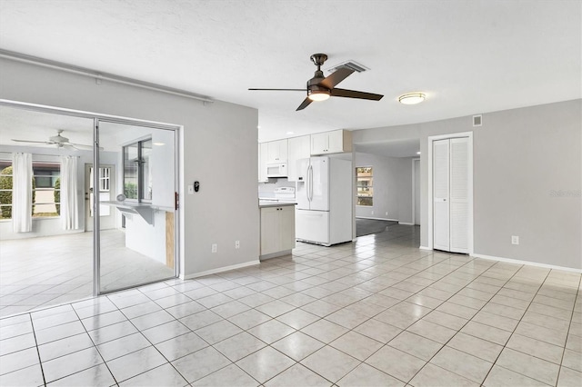 unfurnished living room featuring light tile patterned floors, visible vents, baseboards, and a ceiling fan