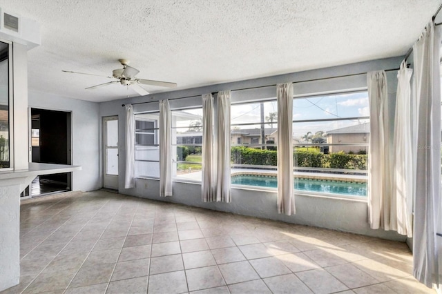 unfurnished sunroom featuring a ceiling fan and visible vents