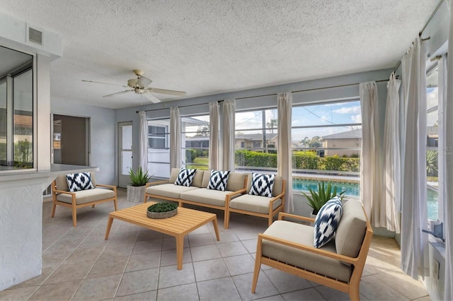 sunroom / solarium featuring a ceiling fan, visible vents, and a wealth of natural light