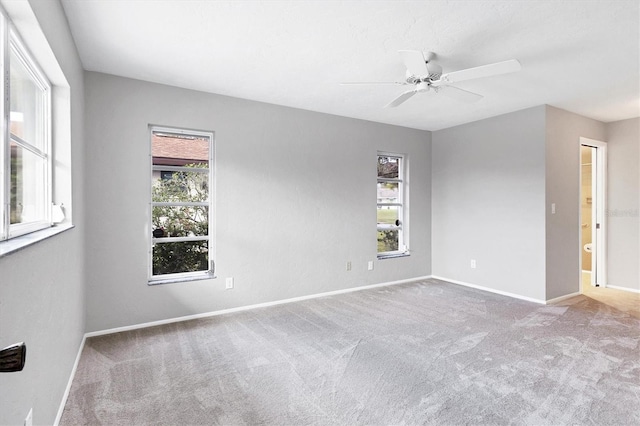 empty room with baseboards, carpet floors, a healthy amount of sunlight, and a ceiling fan