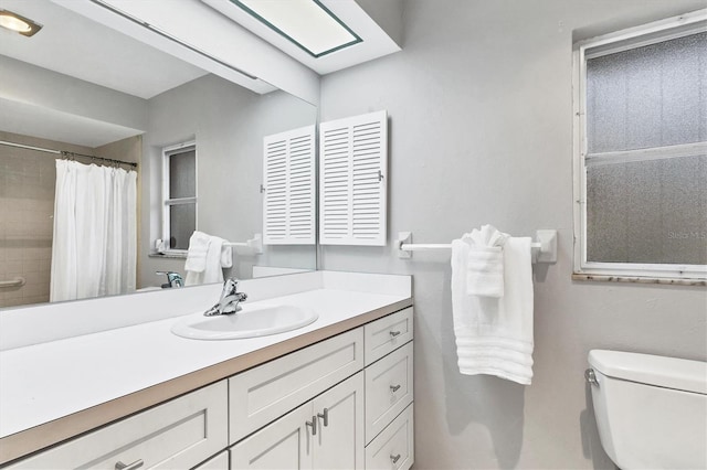 bathroom featuring a shower with shower curtain, toilet, and vanity