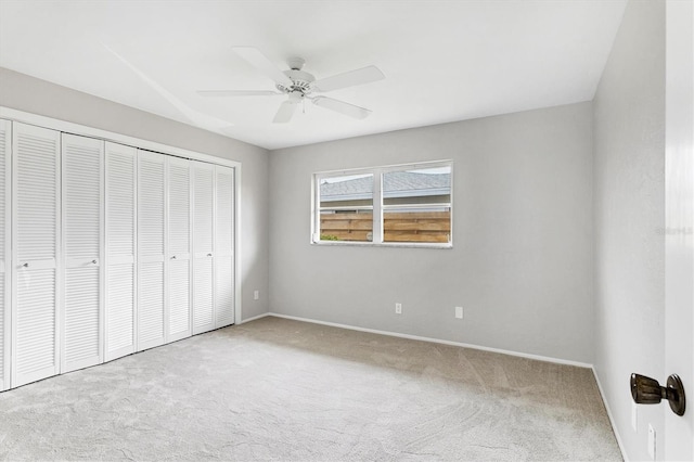 unfurnished bedroom with a closet, baseboards, a ceiling fan, and carpet flooring