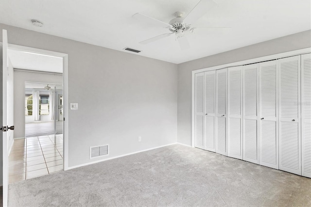 unfurnished bedroom featuring a closet, visible vents, ceiling fan, and carpet floors