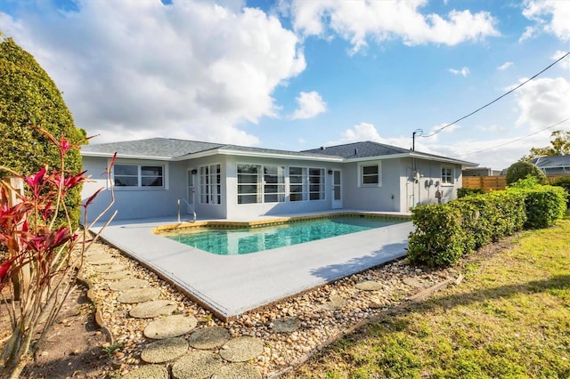 rear view of house featuring an outdoor pool, stucco siding, a patio, and fence