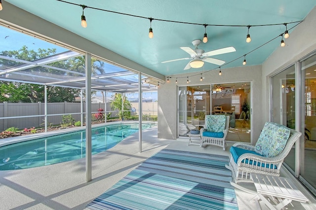 view of swimming pool with ceiling fan, a fenced backyard, a lanai, a fenced in pool, and a patio area