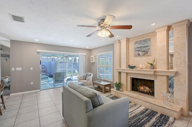 living area with visible vents, a high end fireplace, ceiling fan, tile patterned flooring, and baseboards