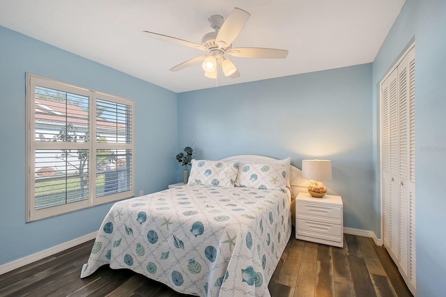 bedroom with dark wood-type flooring, a closet, ceiling fan, and baseboards