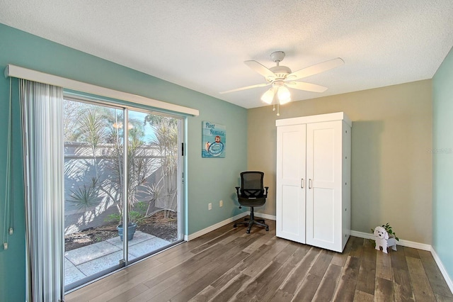 unfurnished bedroom featuring dark wood-type flooring, access to exterior, a textured ceiling, and baseboards