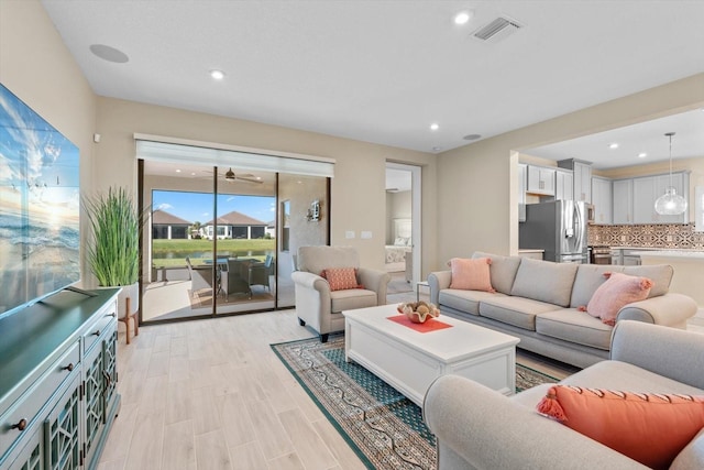 living area with light wood-type flooring, recessed lighting, and visible vents