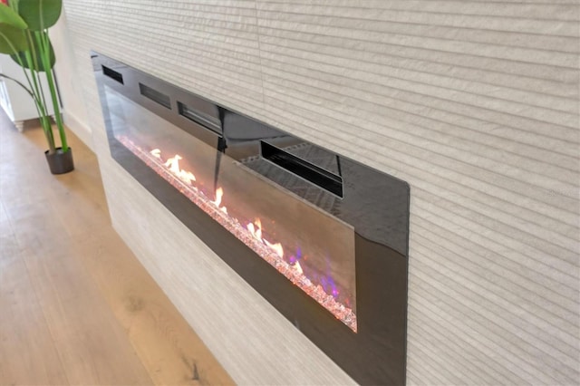 interior details with wood finished floors and a glass covered fireplace