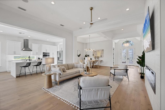 living area with french doors, recessed lighting, an inviting chandelier, and light wood-style floors