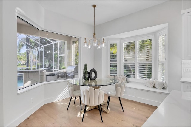 dining room with plenty of natural light, a sunroom, and light wood-style floors