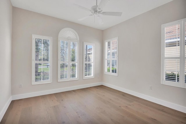 spare room featuring a ceiling fan, baseboards, and wood finished floors