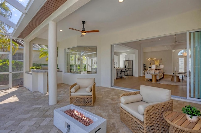 view of patio featuring an outdoor fire pit, a lanai, and a ceiling fan