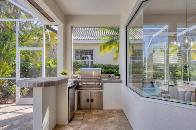 view of patio / terrace with area for grilling and a lanai