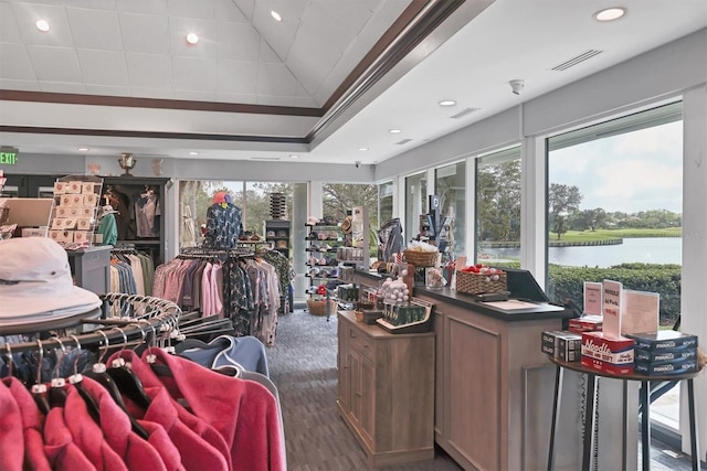 interior space with a water view, plenty of natural light, visible vents, and dark wood finished floors