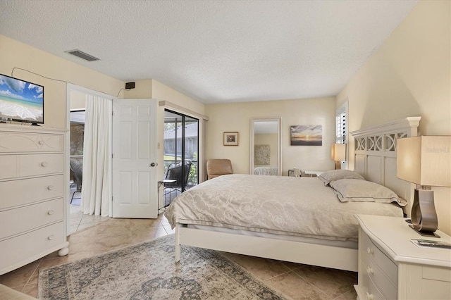 bedroom featuring access to outside, visible vents, tile patterned flooring, and a textured ceiling