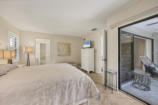 bedroom with access to outside, visible vents, and a textured ceiling