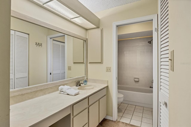 bathroom featuring a closet, toilet, a textured ceiling, vanity, and tile patterned floors