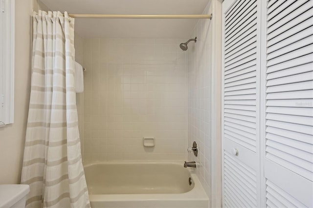 bathroom featuring toilet, a closet, and shower / bath combination with curtain