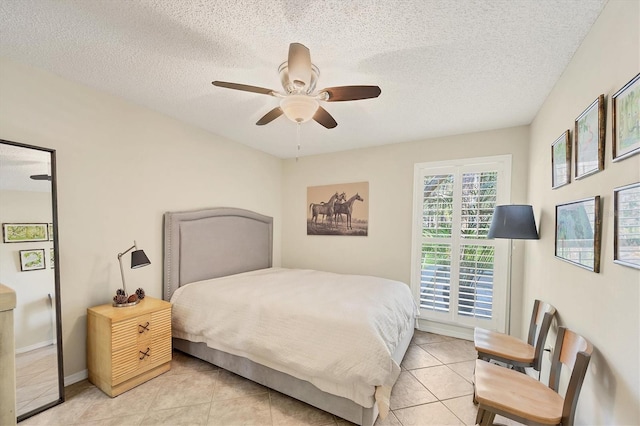 bedroom with a textured ceiling, ceiling fan, light tile patterned floors, and baseboards