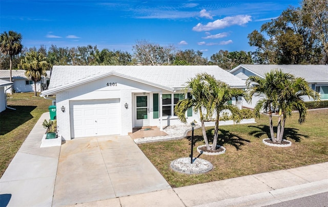 ranch-style home featuring a garage, concrete driveway, brick siding, and a front yard