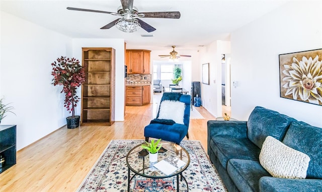 living room with ceiling fan and light wood-type flooring