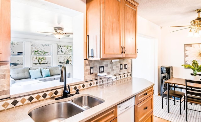 kitchen featuring tasteful backsplash, a sink, a textured ceiling, ceiling fan, and dishwasher