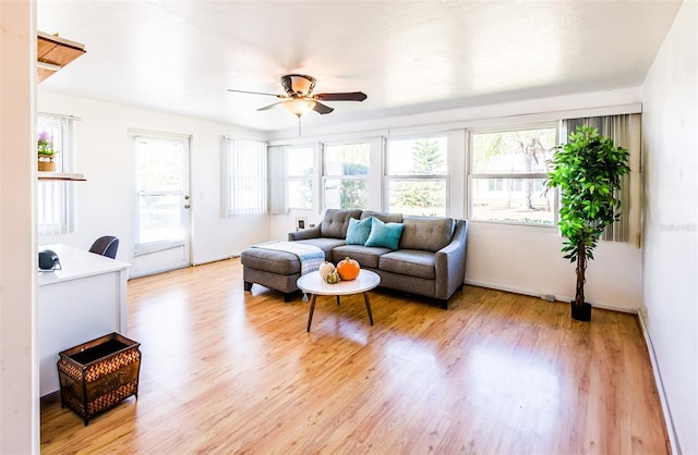 living area with light wood finished floors and a ceiling fan