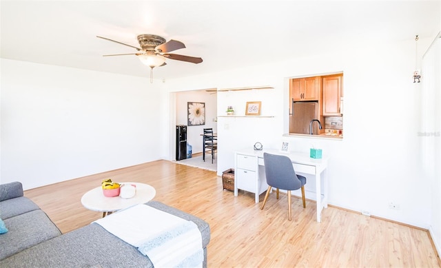 living room with ceiling fan and light wood-style flooring