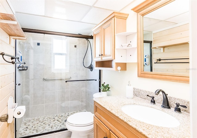 full bath featuring toilet, a stall shower, and vanity