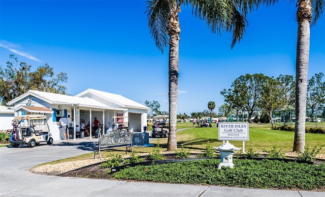 view of community featuring driveway and a yard