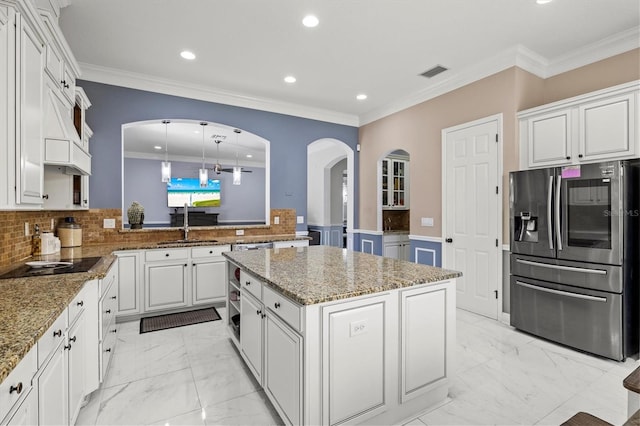 kitchen with arched walkways, marble finish floor, stainless steel fridge, and visible vents