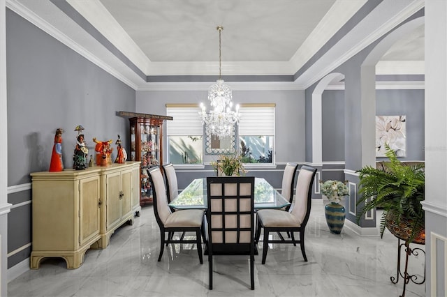 dining space featuring a chandelier, arched walkways, marble finish floor, a tray ceiling, and crown molding