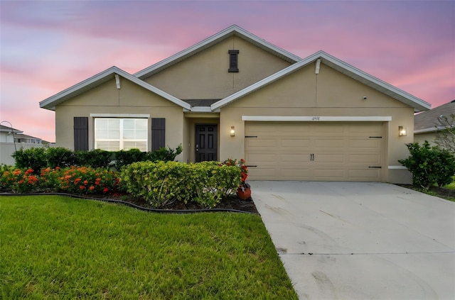 4918 Gray Owl Ter, Palmetto, FL 34221 - view of front of home featuring stucco siding, an attached garage, concrete driveway, and a lawn